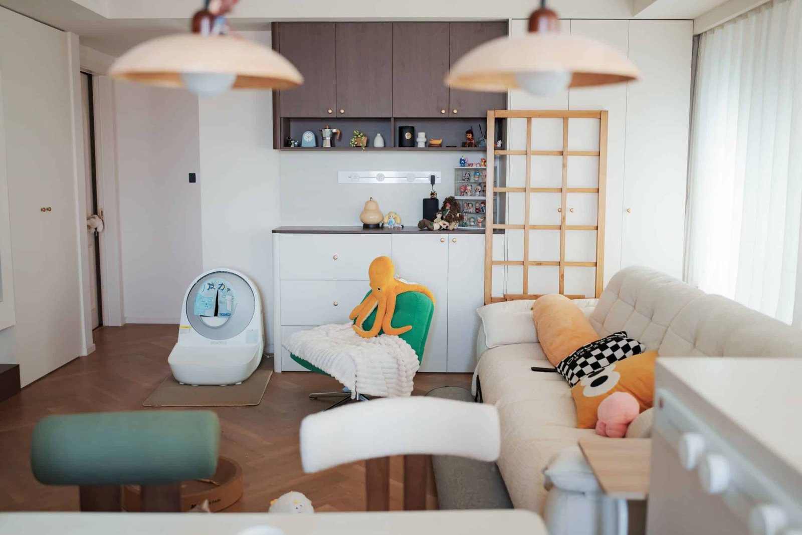 Charming modern living room featuring comfortable seating and playful plush toys, ideal for family relaxation.